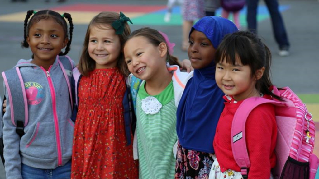 group of elementary students with arms around each other's shoulders