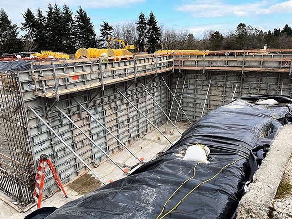 a large pit has metal forms holding up the sides with metal supports bracing them