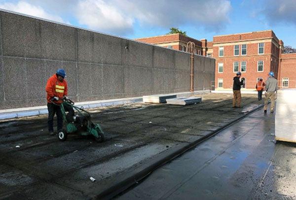 people working with machines on a roof