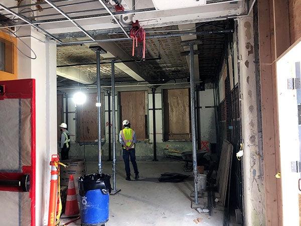 a person stands in a room under construction with metal posts