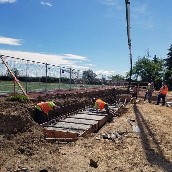 workers smoothing concrete in a frame