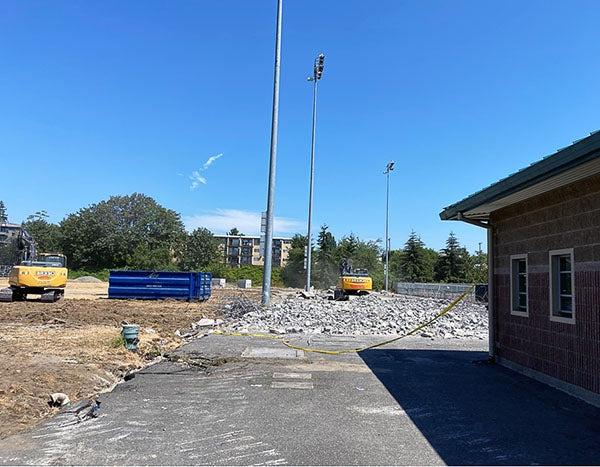 a small building inf ront of construction debris and light poles