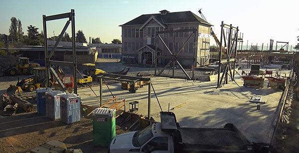 a 3-story historic school house sits amidst construction activities