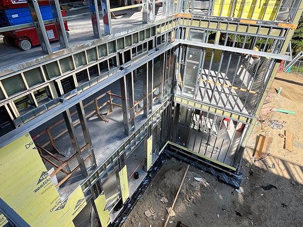 a three story building under construction with metal studs going up