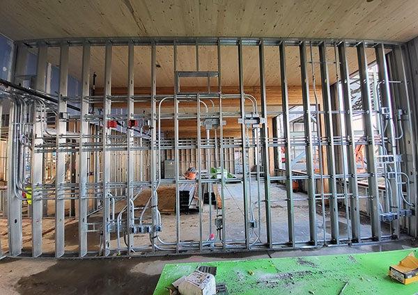 interior of a building under construction with metal studs and electrical conduit