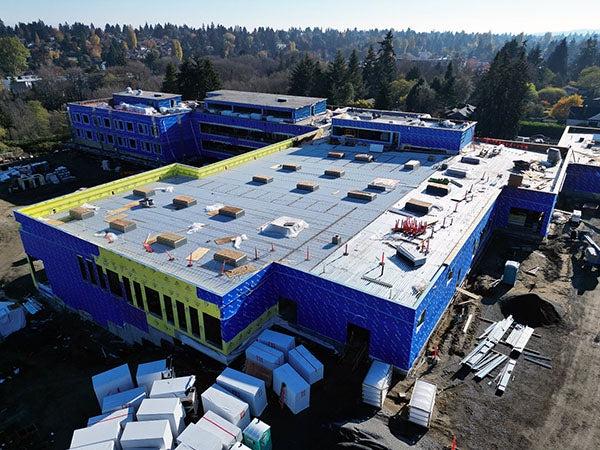 aerial view of a part of a large building with blue walls and construction equipment