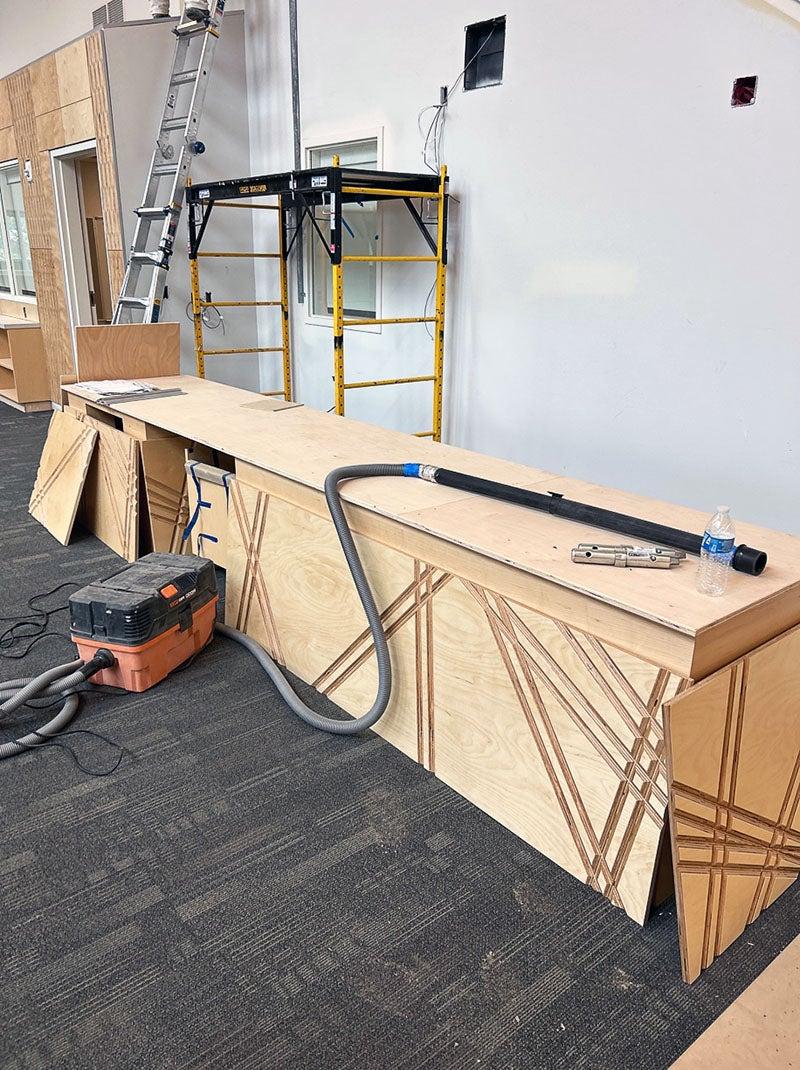 a table has textured wooden panels being installed on the side