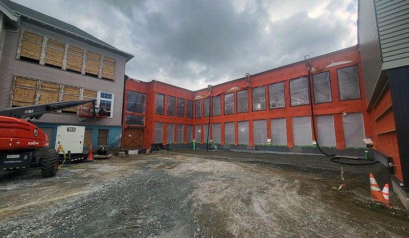 an unfinished courtyard area surrounded on three sides by a building under construction