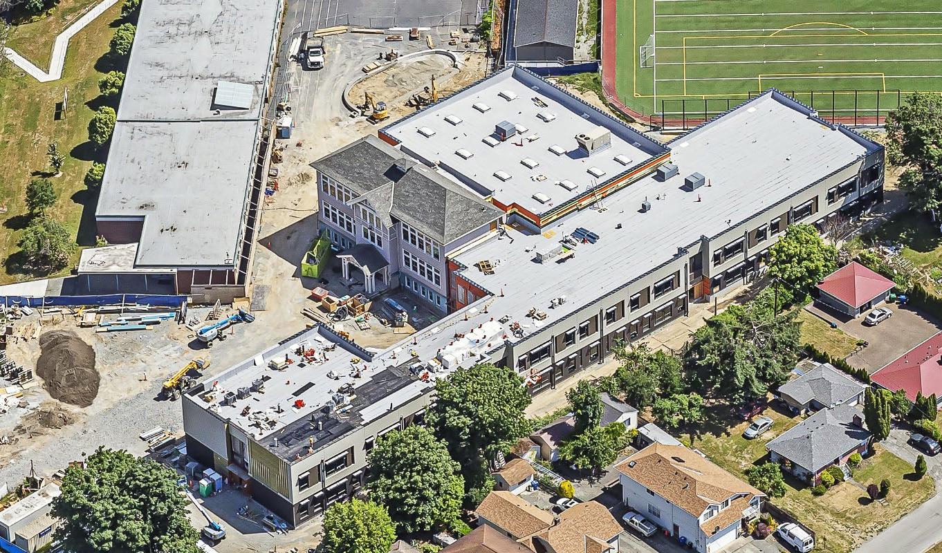 aerial view of two buildings one at a 45 degree angle to the other. construction work is going on at the building exterior