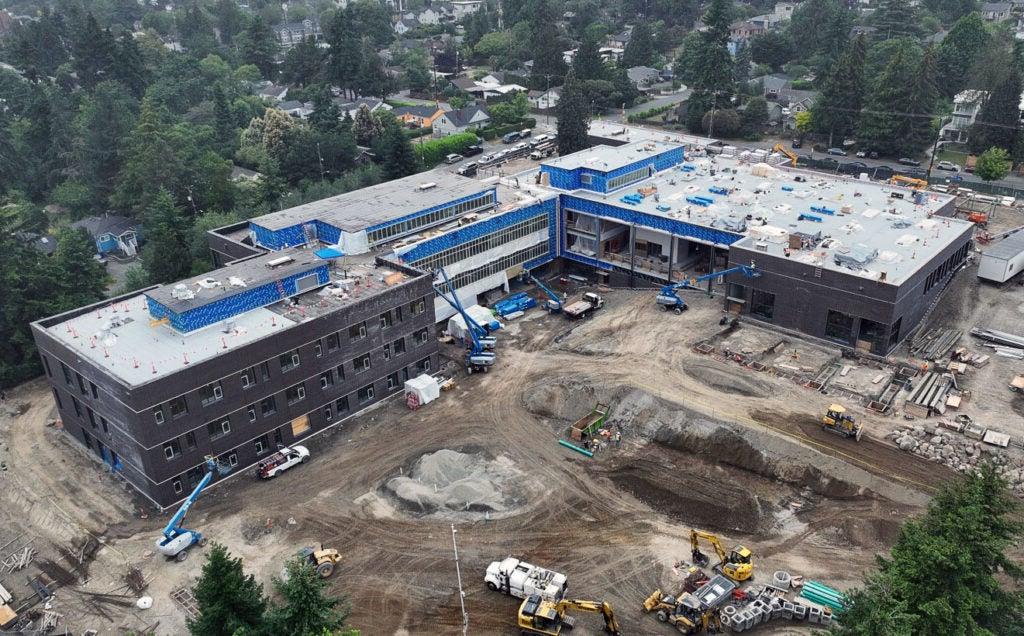 aerial photo showing various construction work on a large L shaped building