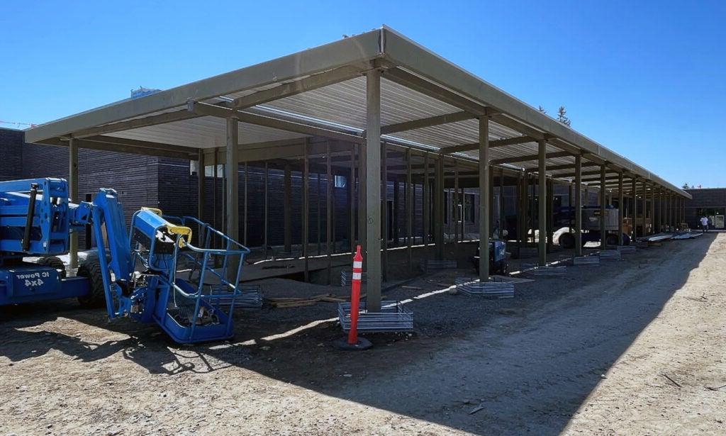 a breezeway with metal posts is in front of a building