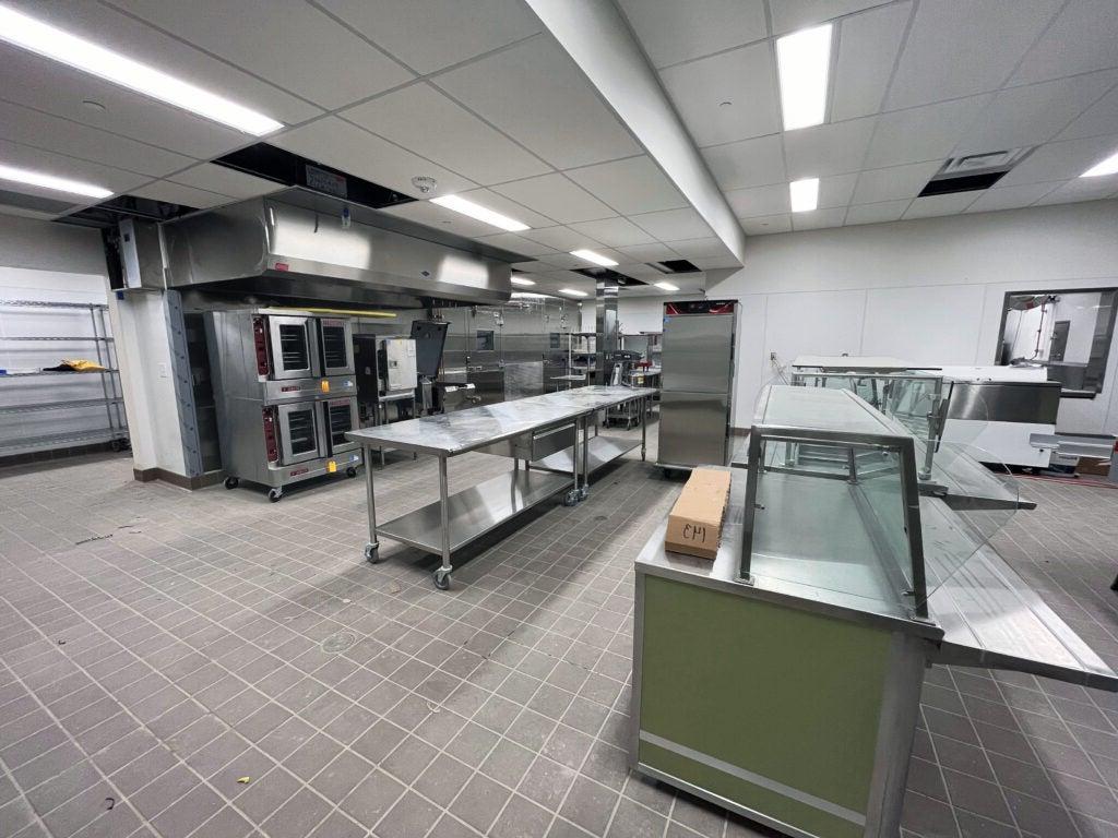 a large room with tile floors and metal kitchen equipment