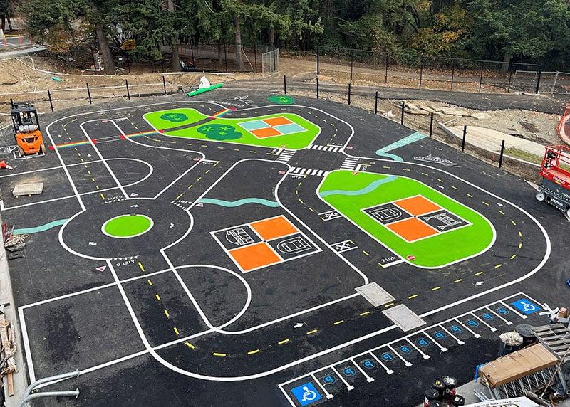 a paved area has a play area road and parking painted on it