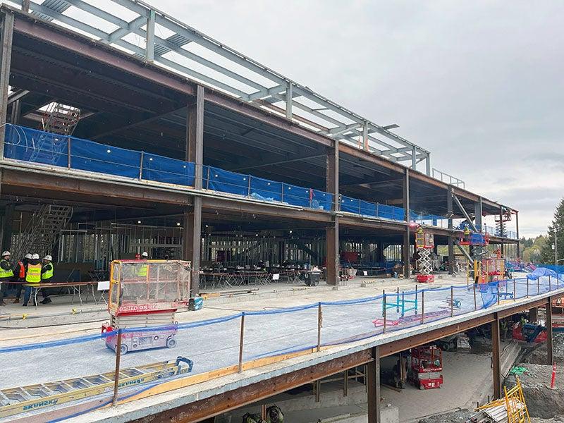 part of a large building under construction with the second floor sticking out much further than the framed building and 3rd floor