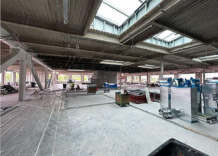 a celing has skylights framed in above a concrete floor with construction materials