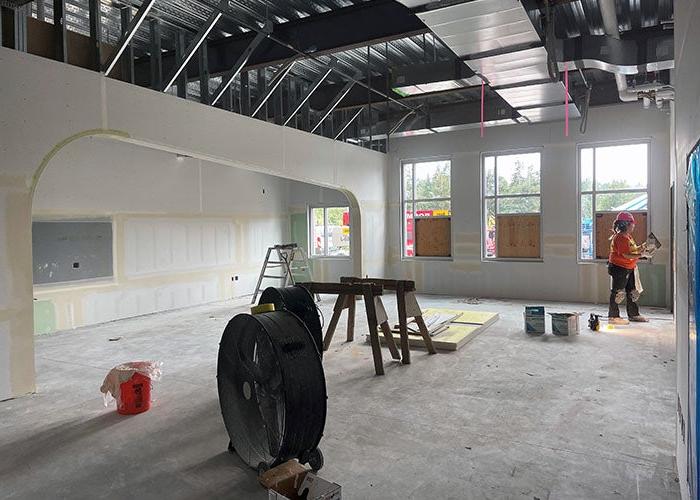 a partially finished room under construction with a person working on wallboard