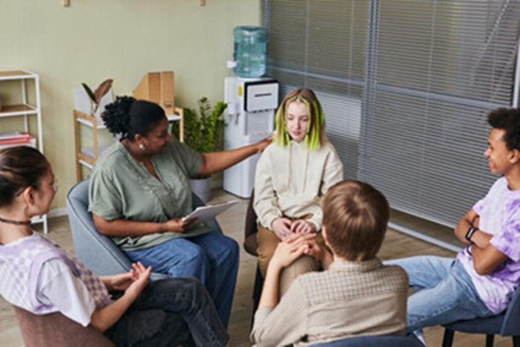 A student is shown with a support group of their peers.