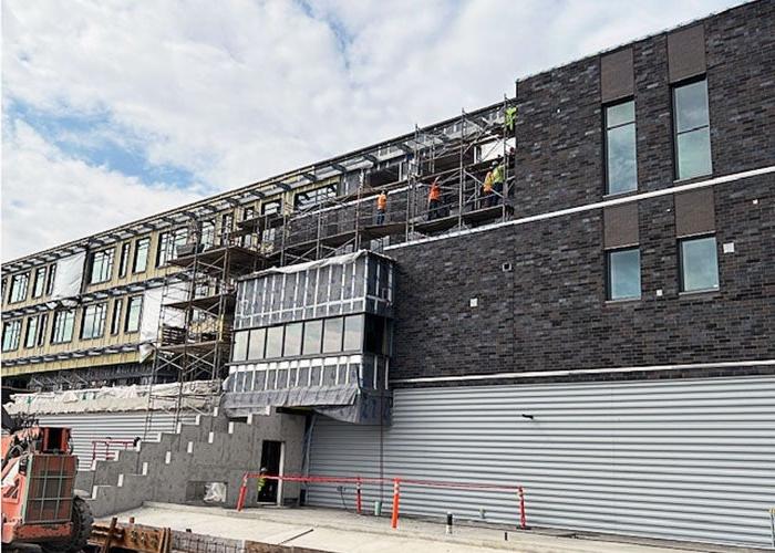 a building under construction with people working on a scafforld on the third level